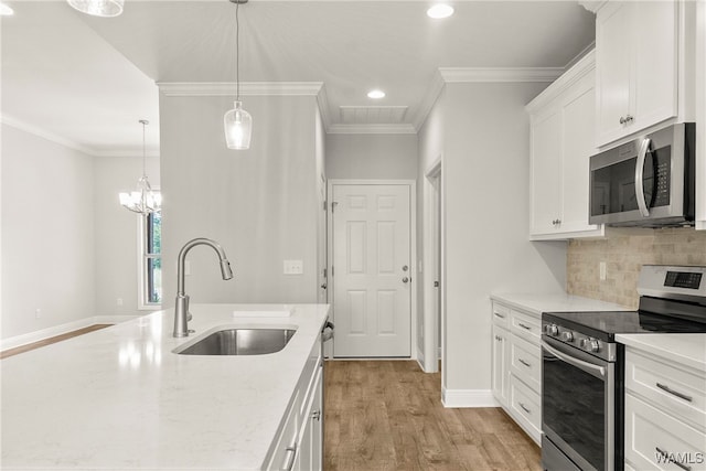 kitchen featuring sink, light stone countertops, light wood-type flooring, appliances with stainless steel finishes, and white cabinetry