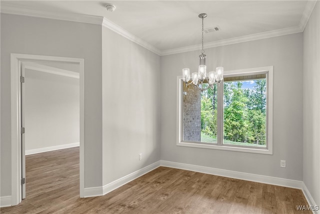 spare room featuring a chandelier, wood-type flooring, and ornamental molding