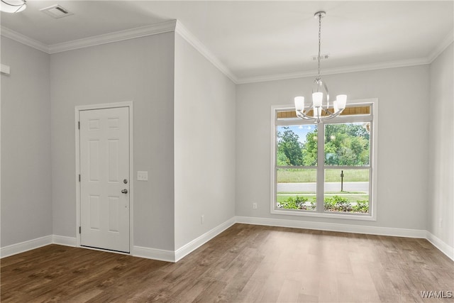 empty room featuring dark hardwood / wood-style flooring, an inviting chandelier, and ornamental molding