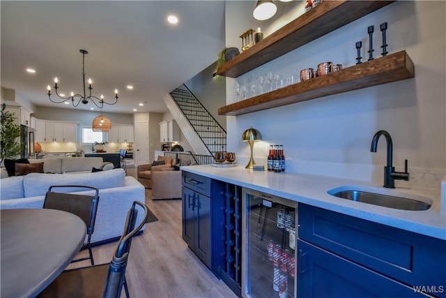 bar with recessed lighting, hanging light fixtures, stairway, light wood-style floors, and a sink