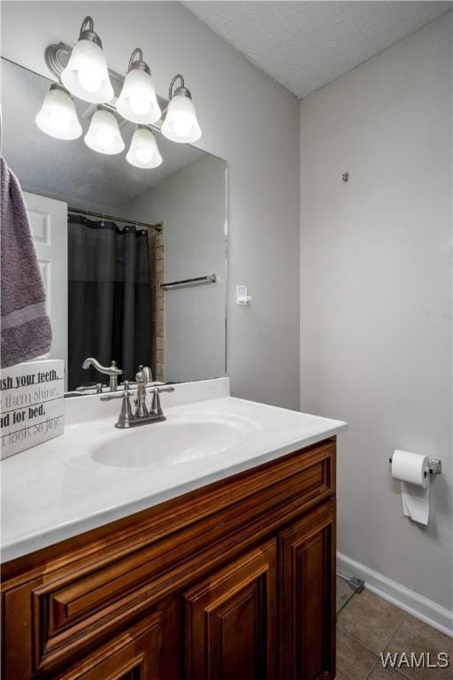 full bathroom with vanity, tile patterned floors, baseboards, and a textured ceiling