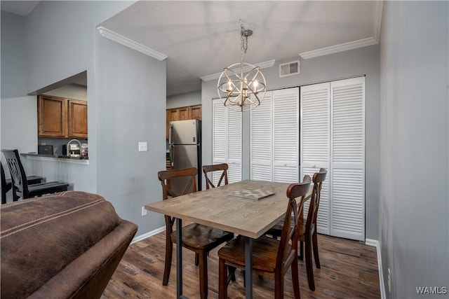 dining space featuring visible vents, crown molding, baseboards, dark wood finished floors, and a notable chandelier