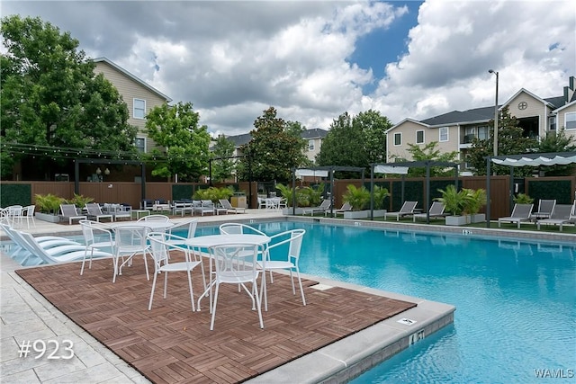 pool with a patio and fence