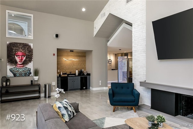 living room with visible vents, baseboards, and a high ceiling