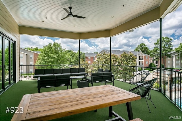 sunroom / solarium featuring a residential view and ceiling fan