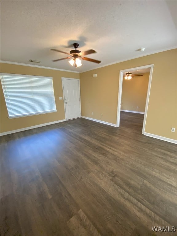 spare room featuring a textured ceiling, crown molding, and dark wood-type flooring