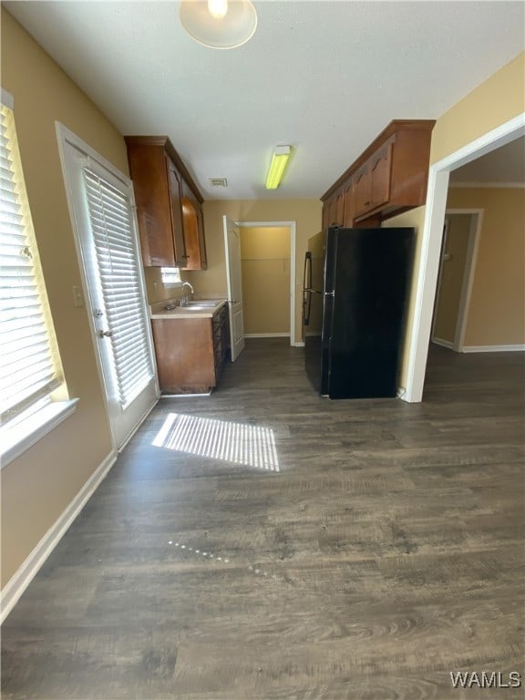 kitchen featuring black fridge and dark wood-type flooring