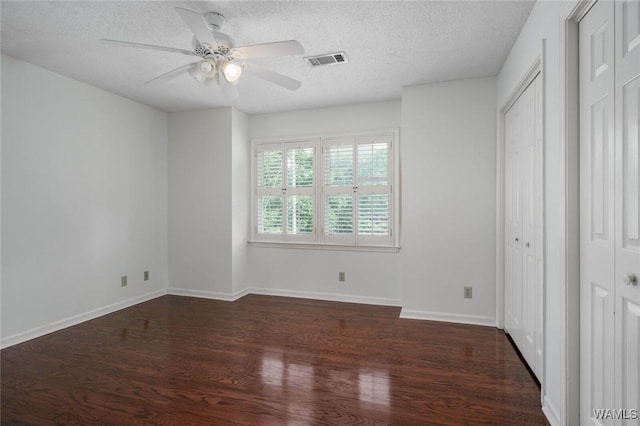 4410 Nicholas Ave, Northport, AL 35473 - unfurnished bedroom featuring dark wood finished floors, a textured ceiling, and a ceiling fan