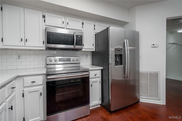 4410 Nicholas Ave, Northport, AL 35473 - kitchen featuring appliances with stainless steel finishes, dark wood-type flooring, light countertops, and decorative backsplash