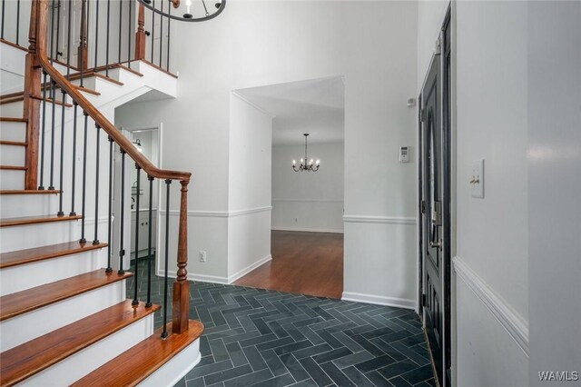4410 Nicholas Ave, Northport, AL 35473 - entryway featuring a chandelier, stairs, a towering ceiling, and parquet floors