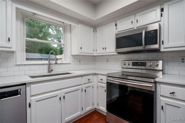 4410 Nicholas Ave, Northport, AL 35473 - kitchen with stainless steel appliances, light countertops, white cabinets, and decorative backsplash