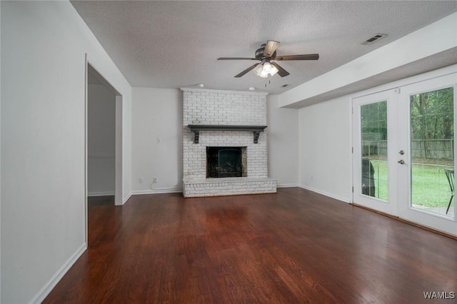 4410 Nicholas Ave, Northport, AL 35473 - unfurnished living room with a textured ceiling, ceiling fan, wood finished floors, and a brick fireplace