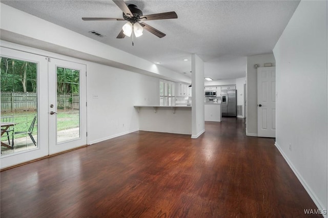4410 Nicholas Ave, Northport, AL 35473 - unfurnished living room with french doors, plenty of natural light, dark wood finished floors, ceiling fan, and a textured ceiling