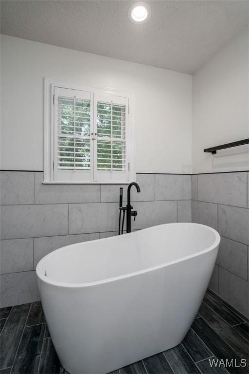 4410 Nicholas Ave, Northport, AL 35473 - bathroom featuring tile walls, a freestanding bath, a wainscoted wall, and recessed lighting