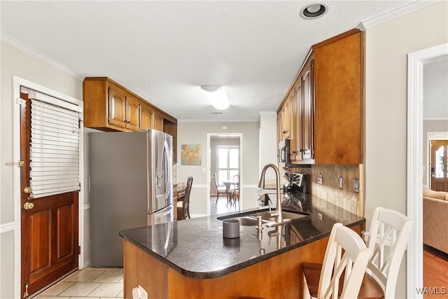 kitchen featuring ornamental molding, appliances with stainless steel finishes, kitchen peninsula, and sink