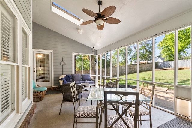 sunroom / solarium with ceiling fan and vaulted ceiling with skylight