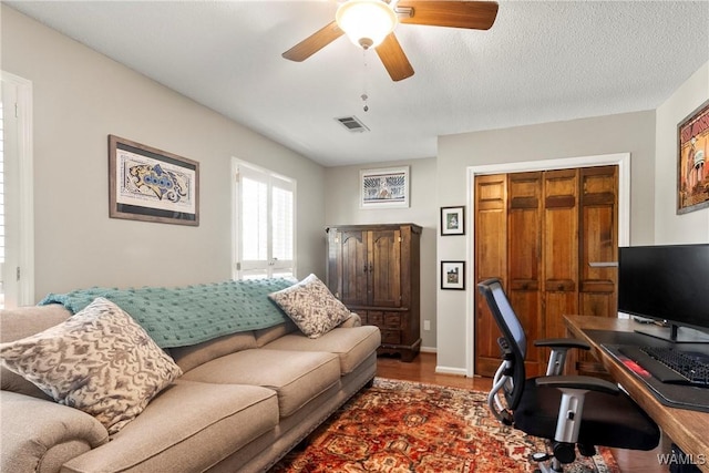 office featuring ceiling fan, wood-type flooring, and a textured ceiling