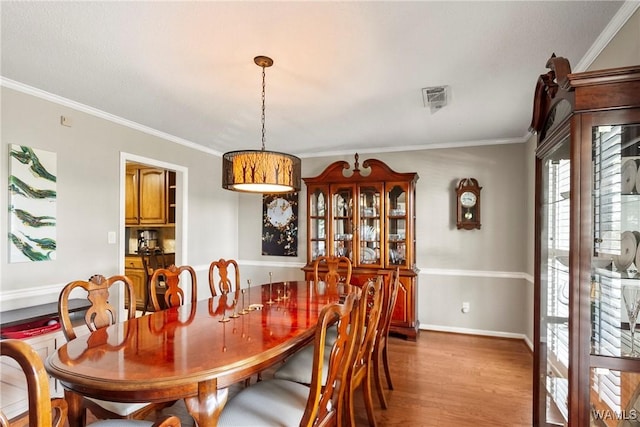 dining room featuring ornamental molding and wood-type flooring