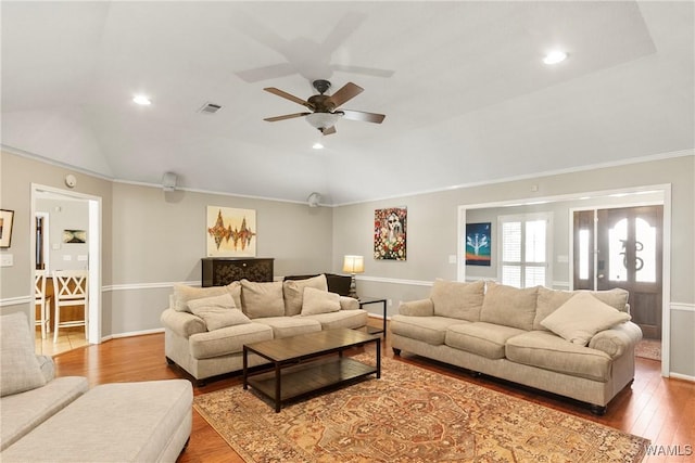 living room with vaulted ceiling, wood-type flooring, crown molding, and ceiling fan