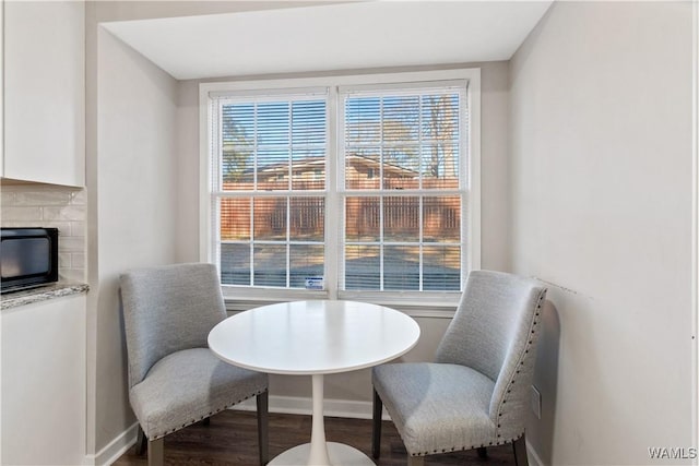 dining room featuring a wealth of natural light, hardwood / wood-style flooring, and a tile fireplace