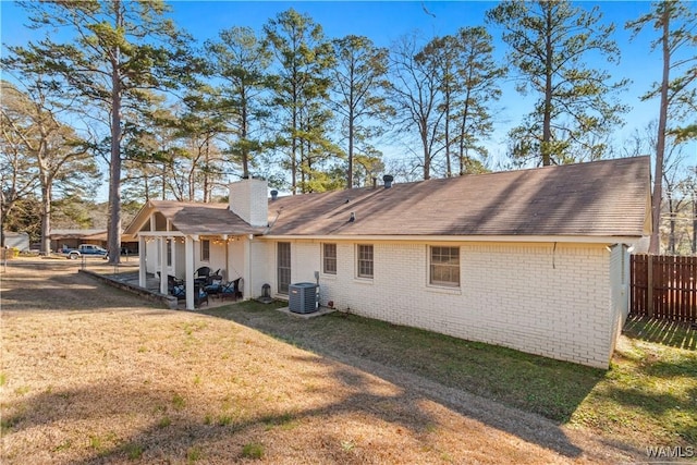 back of house featuring central AC and a yard