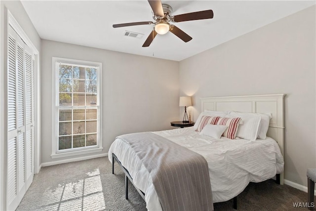 carpeted bedroom with ceiling fan and a closet