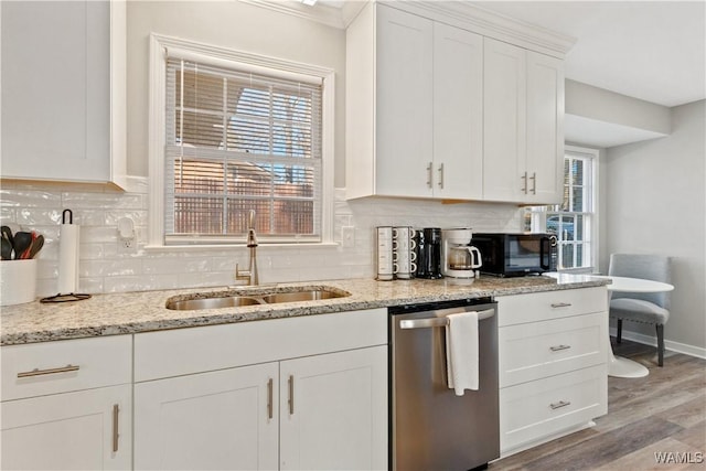 kitchen featuring white cabinetry, light hardwood / wood-style floors, stainless steel dishwasher, light stone counters, and sink