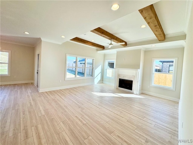 unfurnished living room with beamed ceiling and light hardwood / wood-style flooring