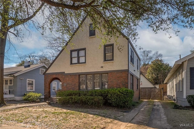 tudor-style house featuring brick siding and stucco siding