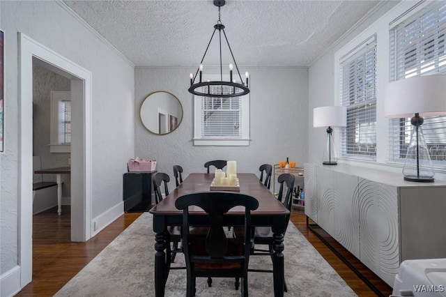 11 Audubon Pl, Tuscaloosa, AL 35401 - dining space featuring a chandelier, a textured wall, dark wood-style floors, and crown molding