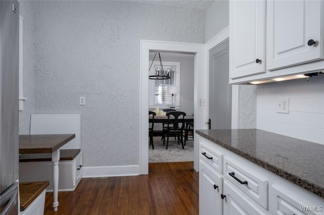 11 Audubon Pl, Tuscaloosa, AL 35401 - kitchen with dark wood-style floors, tasteful backsplash, white cabinetry, and a textured wall