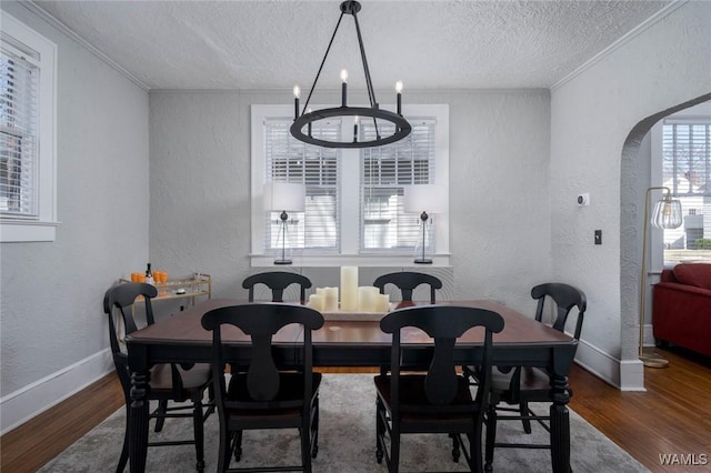 11 Audubon Pl, Tuscaloosa, AL 35401 - dining space featuring arched walkways, a textured wall, wood finished floors, and a chandelier