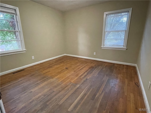 empty room with dark hardwood / wood-style floors