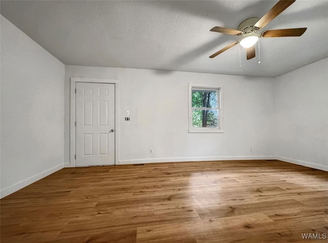 unfurnished room featuring a textured ceiling, light wood-type flooring, and ceiling fan