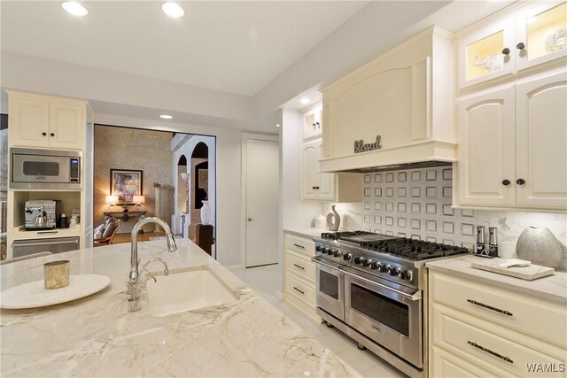 6821 Jade Pt, Tuscaloosa, AL 35406 - kitchen with stainless steel appliances, light stone countertops, recessed lighting, arched walkways, and decorative backsplash