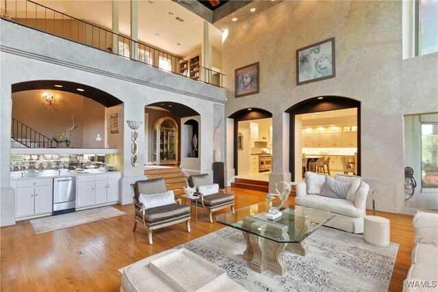 6821 Jade Pt, Tuscaloosa, AL 35406 - living room featuring a towering ceiling, wood finished floors, and arched walkways