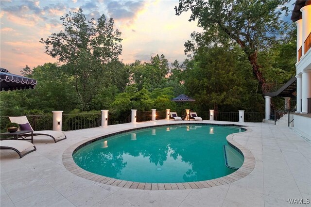 6821 Jade Pt, Tuscaloosa, AL 35406 - pool at dusk featuring a patio and view of wooded area