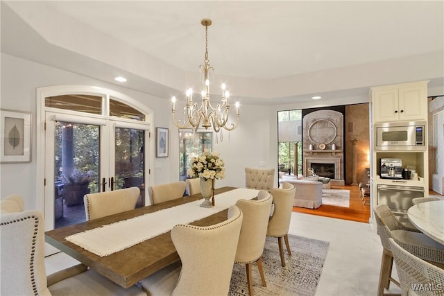 6821 Jade Pt, Tuscaloosa, AL 35406 - dining area with a chandelier, a fireplace, recessed lighting, and french doors
