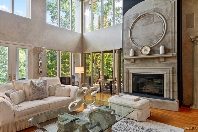 6821 Jade Pt, Tuscaloosa, AL 35406 - living area with wood finished floors, a glass covered fireplace, a high ceiling, and french doors