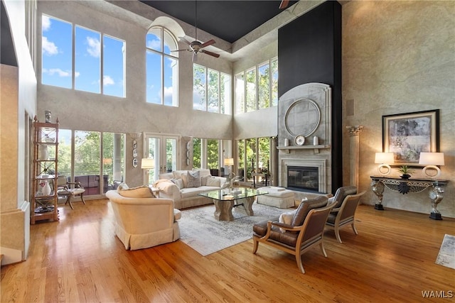 6821 Jade Pt, Tuscaloosa, AL 35406 - living area with wood finished floors, a towering ceiling, ceiling fan, and a large fireplace