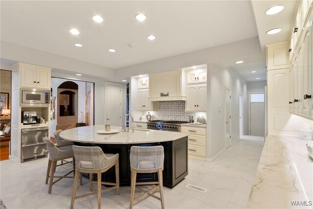 6821 Jade Pt, Tuscaloosa, AL 35406 - kitchen featuring stainless steel microwave, range, a kitchen breakfast bar, light stone countertops, and recessed lighting