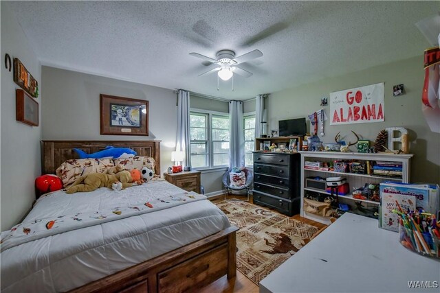 4402 Lakeshore Dr, Northport, AL 35473 - bedroom with wood finished floors, a textured ceiling, and ceiling fan