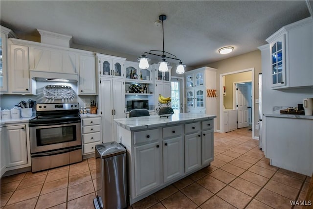 4402 Lakeshore Dr, Northport, AL 35473 - kitchen with electric range, washing machine and clothes dryer, white cabinetry, and light tile patterned flooring