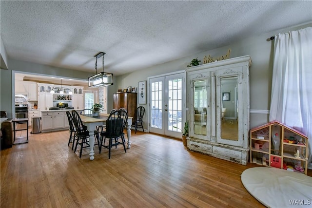 4402 Lakeshore Dr, Northport, AL 35473 - dining area featuring french doors, a textured ceiling, and light wood-style flooring