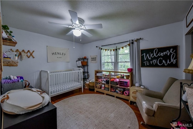 4402 Lakeshore Dr, Northport, AL 35473 - bedroom with wood finished floors, a ceiling fan, and a crib