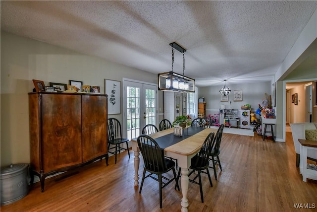 4402 Lakeshore Dr, Northport, AL 35473 - dining room featuring wood finished floors, a textured ceiling, french doors, and a chandelier