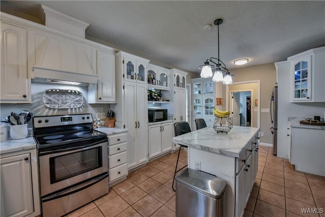 4402 Lakeshore Dr, Northport, AL 35473 - kitchen with stainless steel electric stove, black microwave, white cabinetry, and light tile patterned flooring