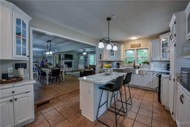4402 Lakeshore Dr, Northport, AL 35473 - kitchen featuring white cabinets, a kitchen breakfast bar, plenty of natural light, and a center island