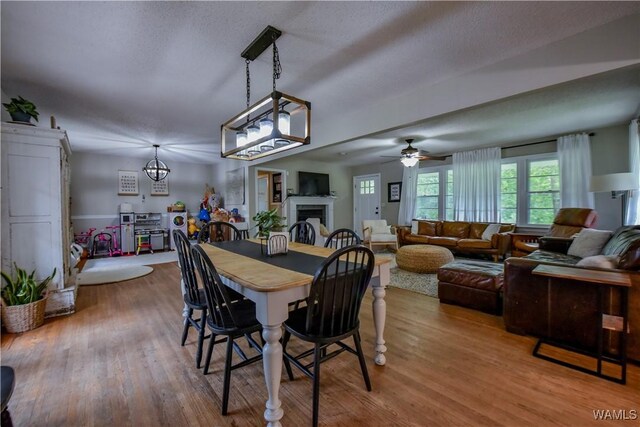 4402 Lakeshore Dr, Northport, AL 35473 - dining room with a fireplace, a ceiling fan, and wood finished floors