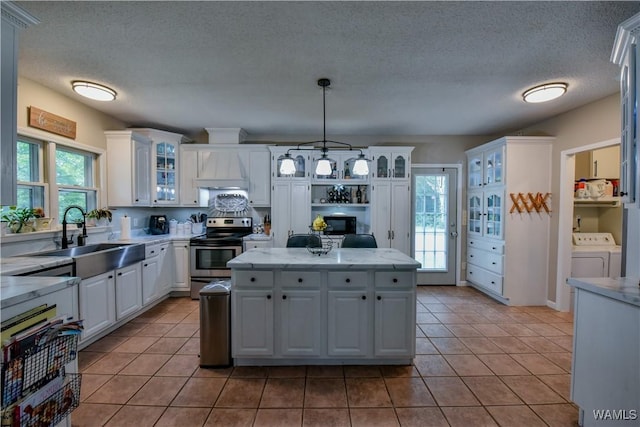 4402 Lakeshore Dr, Northport, AL 35473 - kitchen with stainless steel electric range oven, white cabinets, glass insert cabinets, decorative light fixtures, and light tile patterned flooring